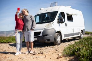 Happy couple in front of class B campervan RV rental fireside RV rental on rvngo main image blog