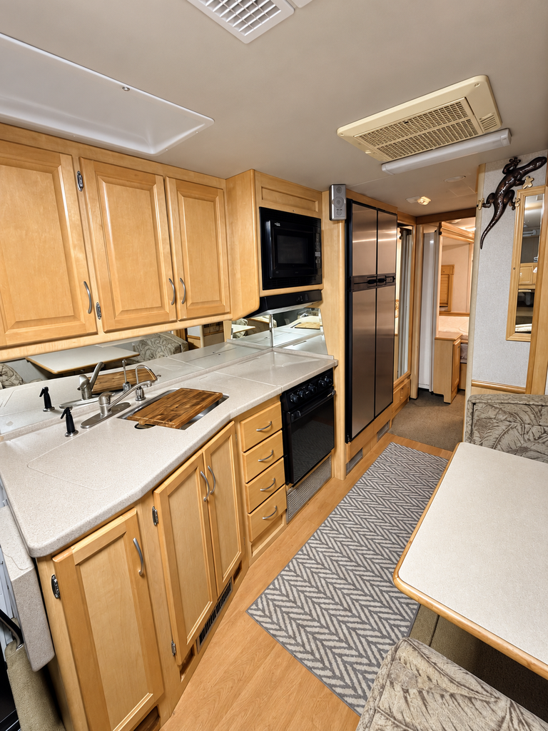 Brightened RV kitchen and dinette interior.png - 2004 Fleet Wood Class A Motorhome rental photo 5